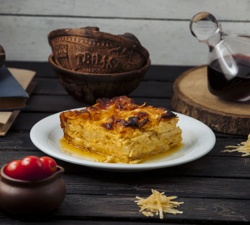 Ein köstlicher Auflauf frisch aus dem Ofen. Der Auflauf ist mit einer Mischung aus zartem Hühnchen, frischem Gemüse und cremiger Käsesauce zubereitet. Die goldbraune Kruste obenauf verleiht dem Auflauf eine verlockende Knusprigkeit. Dieses appetitliche Bild zeigt einen Auflauf, der perfekt nach einem herzhaften Auflauf Rezept zubereitet wurde.